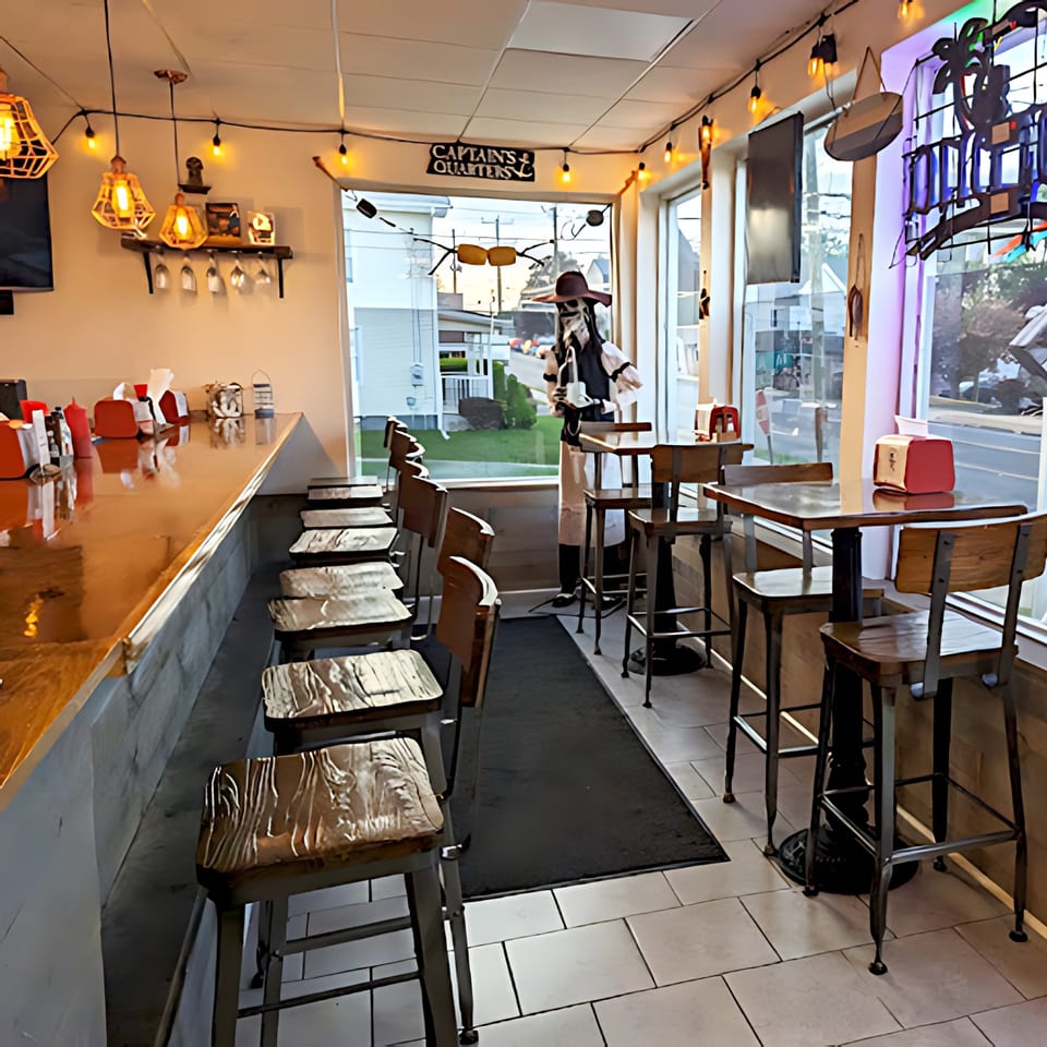 Interior of Willys Pub & Grub, showing a bar with stools, tables, and a pirate mannequin.